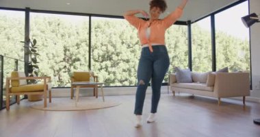 Fitness rutininin tadını çıkarmak, artı modern oturma odasında enerjik bir şekilde dans eden boyunda bir kadın. egzersiz, yaşam tarzı, sağlık, ev çalışması, neşe, vücut pozitifliği