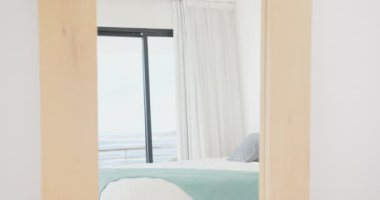 Rahat yatağı ve açık mavi battaniyesi olan modern yatak odası aynada yansıyor. İç mekan, dekor, minimalist, ev, mobilya, yansıma