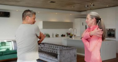 Gülümseyen yaşlı çift modern oturma odasında ayakta duruyor ve konuşuyor. sohbet, aile, yaşam tarzı, mutluluk, birlikte, rahat