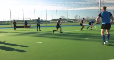 Çim hokeyi oynuyorlar, erkekler açık alanda yoğun bir maç yapıyorlar. Spor, rekabet, takım çalışması, sporcular, yoğunluk, eylem