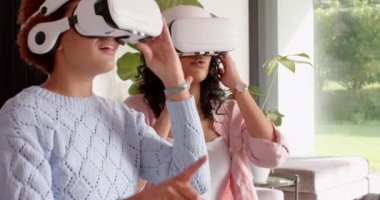 VR kulaklığı kullanan kadın, kadın arkadaşlarıyla sanal gerçeklik deneyiminden zevk alıyor. teknoloji, eğlence, oyun, dalma, etkileşim, arkadaşlık