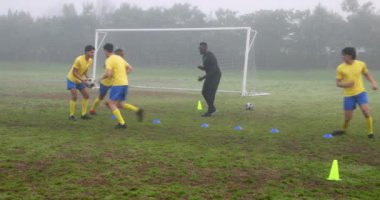 Futbolcular sahada antrenman yaparken koç gözlemliyor. Spor, takım çalışması, fitness, antrenman, egzersiz, oyun oyunu
