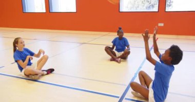 Basketbolla oynamak, çocuklar okul saatlerinde spor salonunda oturmak. Spor, çocuklar, takım çalışması, eğlence, beden eğitimi, spor