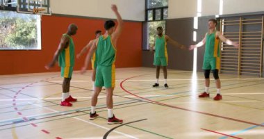 Basketbol takımı spor salonunda ısınıyor, birlikte antrenman yapmaya hazırlanıyorlar. Spor, takım çalışması, egzersiz, sporcular, antrenman, hazırlık
