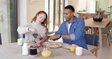 Çeşitli çiftler kahvaltıdan zevk alıyor, gülümsüyor ve evde krep yiyorlar. Mutluluk, bağlanma, sabah, ilişki, birliktelik