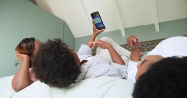 Akıllı telefondan konuşmalar, kadın arkadaşlarının birlikte gülmesi, evde dinlenmesi. Arkadaşlık, teknoloji, cep telefonu, rahatlama, rahatlama, bağlanma