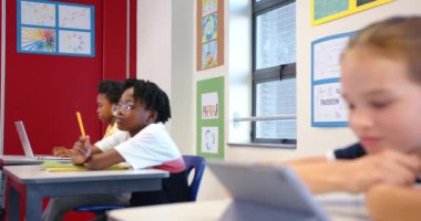 Okulda, sınıfta tablet kullanan bir kız, dijital öğrenmeye odaklanıyor. Eğitim, teknoloji, eğitim, çocukluk