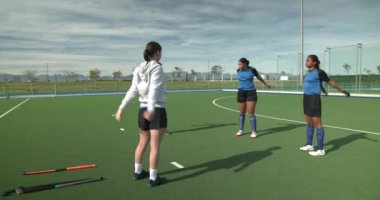 Dişi hokey oyuncuları açık havada antrenmana hazırlanıyorlar. Spor, takım çalışması, ısınma, sporcular, hazırlık, egzersiz