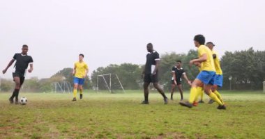 Sahada futbol oynayan sporcular, müsabaka sırasında iş başında olan sporcular. Spor, rekabet, takım çalışması, spor, açık hava