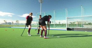 Güneşli sahada tatbikat yaparken, bayan hokey oyuncuları antrenmanlara odaklandı. Spor, takım çalışması, sporcular, yarışma, egzersiz, kadınlar