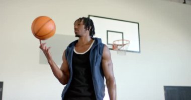 Basketbolu elinde tutan, kapalı okul basketbol sahasında kendine güvenen bir adam. Spor, atletizm, güven, kapalı alan, aktif, fitness