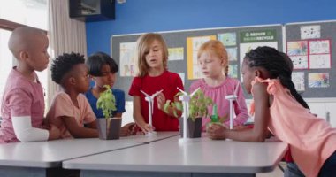 Okulda, çocuklar sınıf projesinde rüzgar türbinleri ve bitkileri tartışıyorlardı. Eğitim, takım çalışması, yenilenebilir enerji, çevre, sürdürülebilirlik