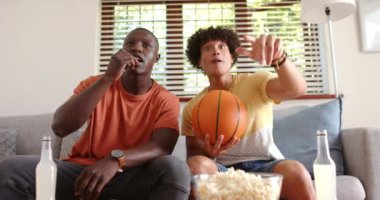 Spor maçı izlerken, iki heyecanlı çok ırklı erkek arkadaş basketbol oynuyorlar ve evde oturuyorlar. Tezahürat, hayranlar, heyecan, arkadaşlık