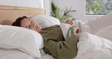 Yatakta uzanan, uyanıp rahat bir yatak odasında gülümseyen bir kadın. Sabah, rahatlama, yaşam tarzı, rahatlık, mutluluk