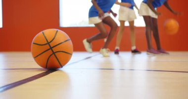 Okulun spor salonunda basketbol oynamak, çocukların antrenman yapması ve birlikte eğlenmesi. Spor, takım çalışması, fitness, çocuklar, egzersiz, eğlence