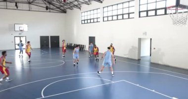 Basketbolcular kapalı sahada, yoğunluk ve odaklanmayla yarışıyorlar. Sporcular, spor, yarışma, takım çalışması, fitness, kararlılık