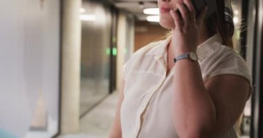 Akıllı telefondan konuşuyor, modern ofis koridorunda iş kadını, sohbete odaklanıyor. şirket, iletişim, profesyonel, teknoloji, ağ, işyeri