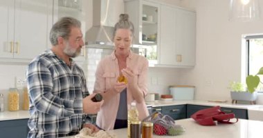 Mutfakta yiyecek ve ev yapımı reçellerle kucaklaşan mutlu, olgun bir çift. yemek, yaşam tarzı, mutluluk, yerli, aşçı, koruma