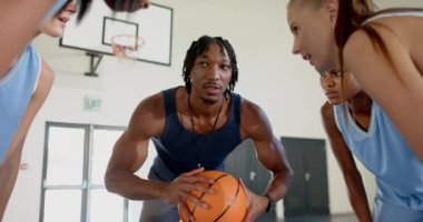 Basketbol oynamak, antrenman sırasında bayan oyunculara koçluk yapmak. Spor, koçluk, antrenman, takım çalışması, sporcular, yarışma