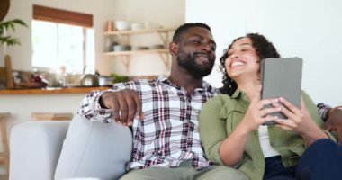 Evde tablet kullanan, mutlu Şükran Günü anlarının tadını çıkaran çok kültürlü bir çift. Teknoloji, bağlantı, yerli, boş zaman, tatil, yaşam tarzı