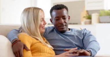 Mutlu, çeşitli çiftler evdeki kanepede dinleniyor, birlikte güzel tatillerin tadını çıkarıyorlar. Rahatlama, birliktelik, bağlanma, rahatlama.