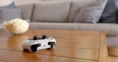 Oyun kumandası ahşap masada, oturma odasında patlamış mısırla, evde, kopyalama alanında. Eğlence, oyun, rahatlama, gevşeme, atıştırma, ev