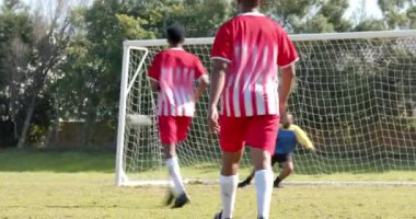 Dışarıda futbol oynuyorlar, spor üniformalı adamlar birlikte oyun oynuyorlar. Takım çalışması, fitness, egzersiz, rekabet, eğlence, atletizm