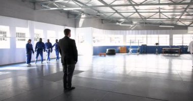 Judo çalışıyor, üniformalı öğrenciler beden eğitimi öğretmeniyle sırada bekliyor. Dövüş sanatları, eğitim, disiplin, takım çalışması, dojo, dövüş