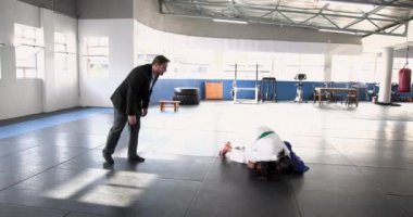 Judo antrenmanı, spor salonunda paspaslarda antrenman yapan iki kişi, tekniğe odaklanmış. Dövüş sanatları, eğitim, dövüş, kendini savunma, fitness, atletik