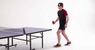 Masa tenisi oynamak, elinde raket olan ve servise hazırlanan genç bir adam. Spor, masa tenisi, atletizm, eğlence, eğlence, rekabet