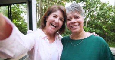 Kıdemli kadınlar dışarıda selfie çekiyorlar, gülümsüyorlar ve bayram anlarının tadını çıkarıyorlar. Yaşam tarzı, arkadaşlık, eğlence, mutluluk, kutlama, fotoğrafçılık