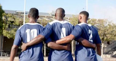Futbol Afro-Amerikan erkek oyuncuları mavi formalarla sahada duruyor ve takım birliğini gösteriyor. Spor, takım çalışması, futbol, sporcular, yoldaşlık, yarışma