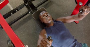 Göğüs presinde ağırlık kaldırmak, spor salonunda spor yapan Afrikalı Amerikalı bir adam. egzersiz, egzersiz, güç, eğitim, vücut geliştirme, kas