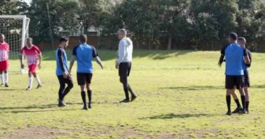 Futbol oynuyorlar, gündüz antrenmanları sırasında sahada gol kutluyorlar. Kutlama, takım çalışması, eğlence, spor