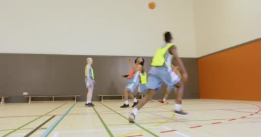 Genç basketbol oyuncuları okul spor salonunda takım çalışması yapıyor ve basket oynuyor. spor, gençlik, eğitim, egzersiz, pratik, atletizm