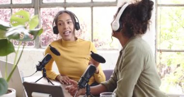 İki çok ırklı bayan meslektaşımız canlı sohbetler yaparak podcast 'i evde kaydediyor. yayın, iletişim, mikrofon, ses, medya, içerik