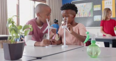 Okulda, çocuklar birlikte rüzgar türbini yapıyorlar, yenilenebilir enerjiyi öğreniyorlar. Eğitim, takım çalışması, bilim, sürdürülebilirlik, yeşil enerji, yenilik