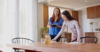 İki Asyalı anne ve kız mutfakta, birlikte yemek hazırlıyorlar, ailecek vakit geçiriyorlar. Yemek pişirme, birliktelik, yemek hazırlama, kaynaşma, yaşam tarzı