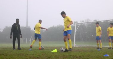 Futbol oynamak, koçluk yapmak sisli sahada kaleyle genç oyuncuları eğitmek. Koçluk, takım çalışması, spor, egzersiz