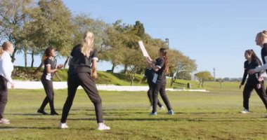 Açık havada kriket antrenmanı, güneşli bir günde birlikte oynayan kadınlar. Spor, antrenman, takım çalışması, egzersiz, fitness, eğlence