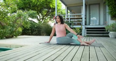 Güvertede yoga yapan bir kadın, mindere uzanan, yeşilliklerle çevrili, fotokopi alanı. Meditasyon, sağlık, rahatlama, fitness, doğa, egzersiz