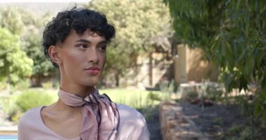 Dışarıda dinlenen, eşarplı bir insan bahçede huzurlu bir anın tadını çıkarıyor. Rahatlama, doğa, sükunet, rahatlık, dinginlik, farkındalık