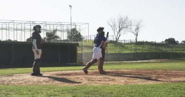 Beyzbol oynayıp, vurmaya hazırlanırken tutucu ve hakem hazır. Spor, rekabet, takım çalışması, eylem, oyun, hazırlık