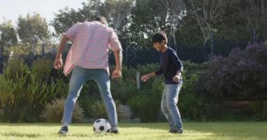 Arka bahçede futbol oynamak, Hintli baba ve oğlu birlikte dışarıda eğlenmek. Aile, bağ, spor, babalık, egzersiz, eğlence