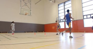 Basketbol oynuyorlar, atletler atış talimi yapıyorlar ve kapalı spor salonunda antrenman yapıyorlar. Spor, atletizm, takım çalışması, antrenman, egzersiz