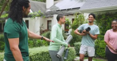 Çeşitli arkadaşlar yoga minderleri tutarak dışarıda toplanıyor, gülümsüyor ve eğleniyorlar. fitness, sağlık, eğlence, egzersiz, topluluk, yaşam tarzı