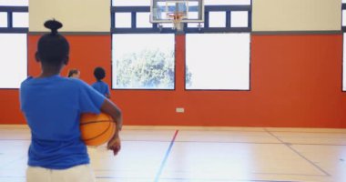 Okulun spor salonunda basketbol oynamak, çocukların top sürme ve atış becerileri. Spor, takım çalışması, egzersiz, egzersiz, fitness, antrenman