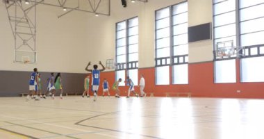 Okulda basketbol oynamak, öğrencilerin kapalı sahada oyun çalışması. Spor, fitness, egzersiz, takım çalışması, rekabet, gençlik