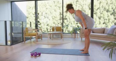 Yoga yapıyor, artı modern oturma odasında paspasa uzanan boyunda bir kadın. Sağlık, zindelik, vücut pozitifliği, rahatlama, ev egzersizi, kişisel bakım.