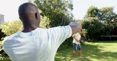 Arka bahçede top tutmaca oynarken, iki çok ırklı erkek arkadaş birlikte dışarıda eğleniyorlar. Eğlence, eğlence, arkadaşlık, kaynaşma, eğlence.